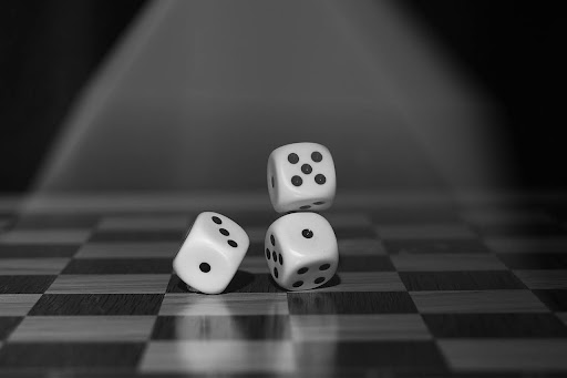 Black and white image of three dice bouncing on a checkered table. Feeling lucky strategic business development Fix and Form brand strategy Denver Colorado
