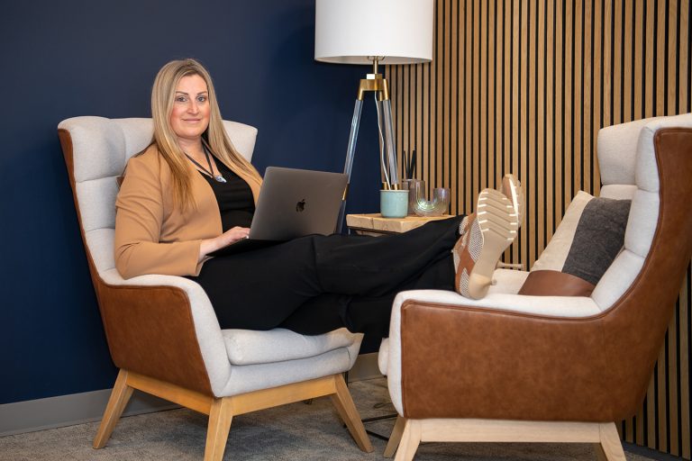 Woman sitting comfortably in a modern office lounge with a laptop, representing Fix & Form’s strategy-first approach to branding and design.