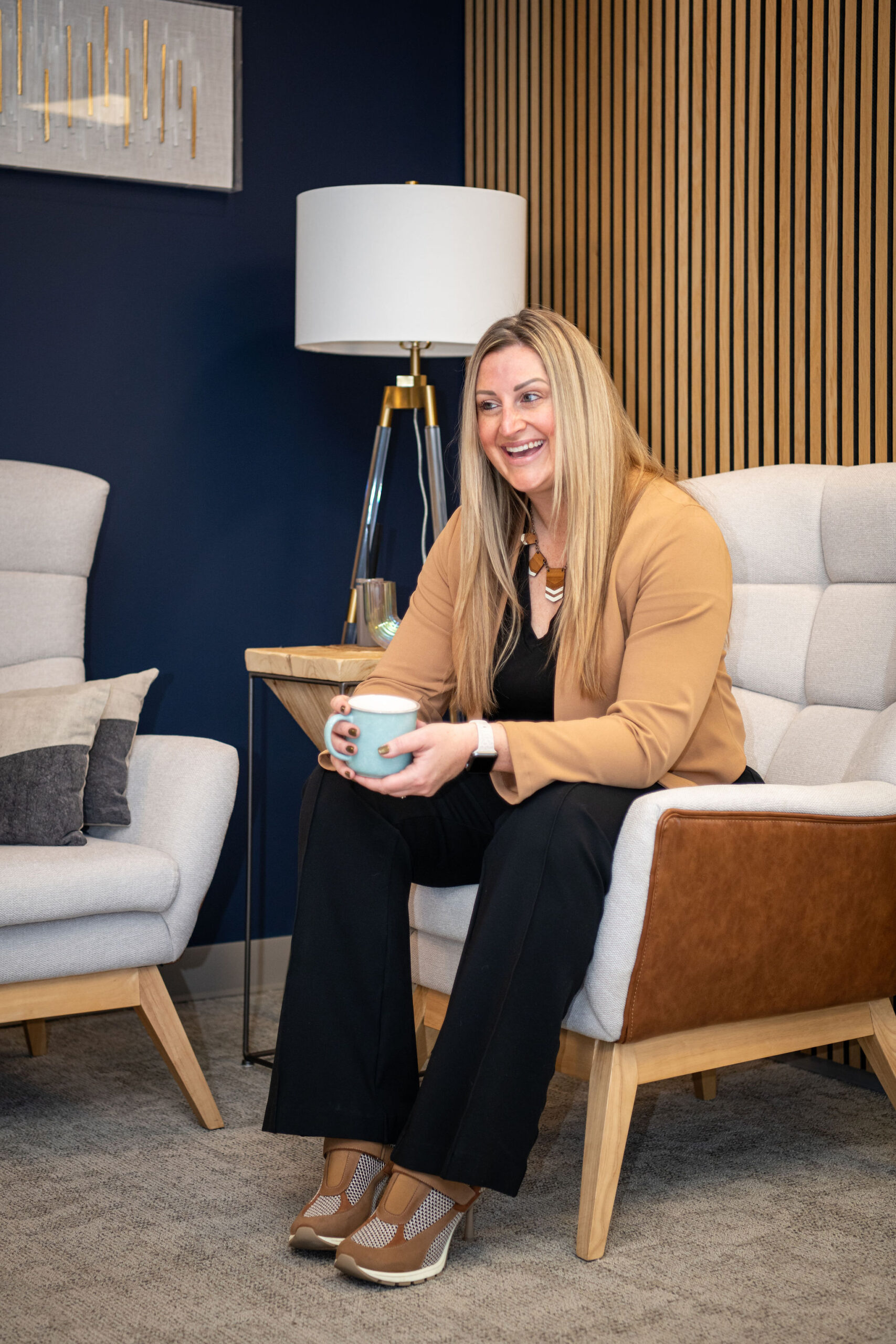 Anne Gillespie, owner of Fix & Form, smiling with her laptop in the Denver office, highlighting monthly marketing support and retainer services.