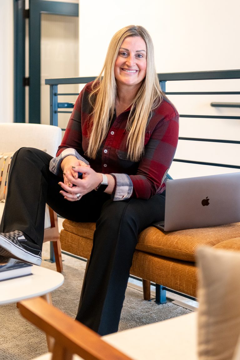 Anne Gillaspie, Brand Therapy strategist and thought leader, sitting with her laptop while preparing brand strategy work for her Denver clients.