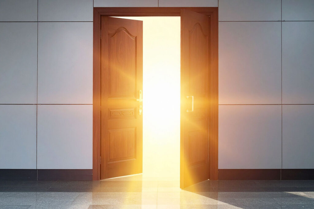 Open doorway filled with bright light, symbolizing transformation, clarity, and moving forward through strategic brand story realignment.