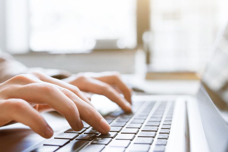 Hands typing on a laptop, representing thoughtful website strategy and brand clarity