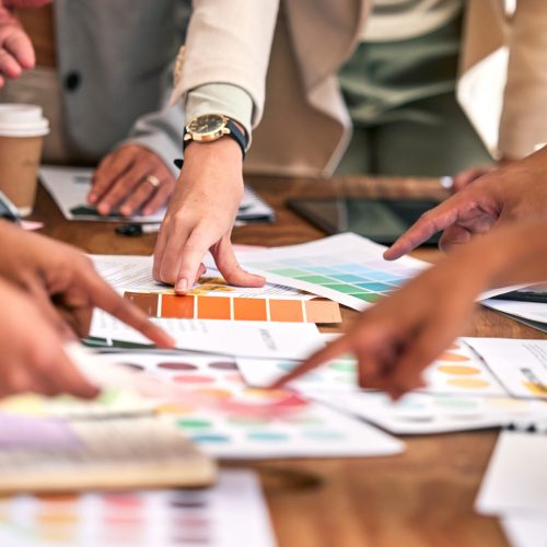 Creative meeting, color and hands of business people on desk for branding logo, strategy and marketing design.